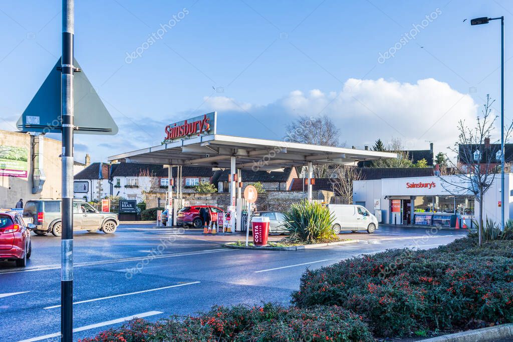 Sainsburys fuel station with vehicles queuing on a sunny winter late afternoon