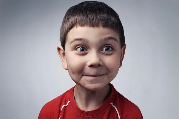 Fröhliche Gesichter - lustige Kinder, die lächeln. Kinderporträt, Emotionen und Spaß fröhlicher 6-jähriger Junge im Atelier Stockbild