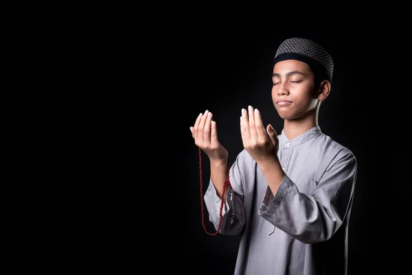 肖像アジアのイスラム教のイスラム教徒の少年は 信仰と決意で祈りを捧げています 黒い背景にコピースペースがあり — ストック写真