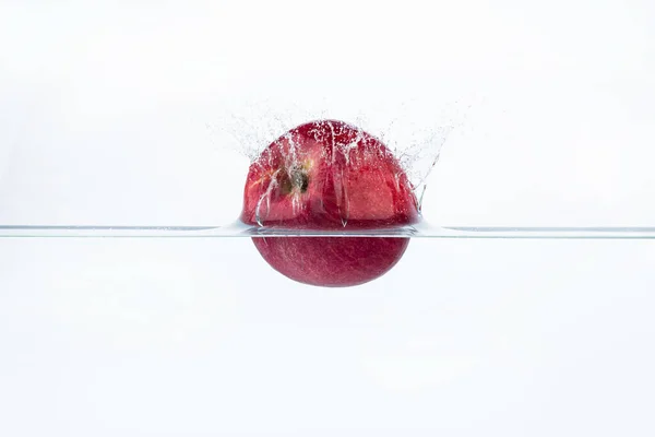 鲜红的苹果在水的飞溅中与白色背景隔离 — 图库照片