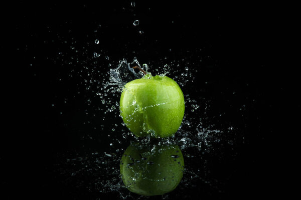 Green apple on black background.