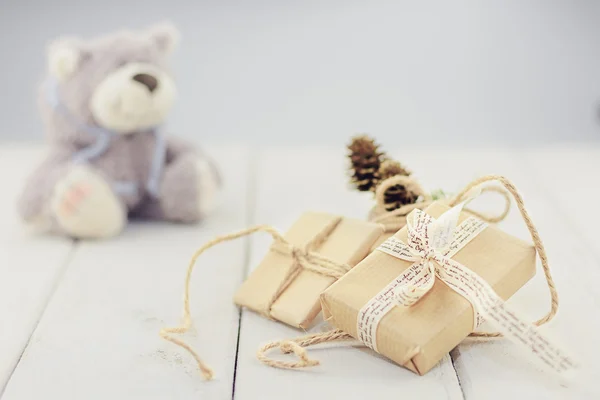 Scatole su uno sfondo di legno chiaro morbido orso giocattolo . — Foto Stock