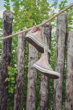 Bahçede bir ip asılı spor ayakkabı.