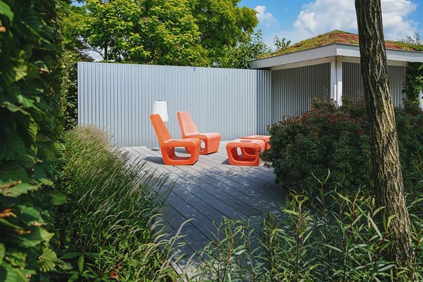 Two orange chair with floor lamp in a recreation area in the gar