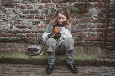 Deventer, Hollanda, 15 Aralık 2018: Deventer 'daki Dickens Festivali sırasında sokakta dilenen küçük kız