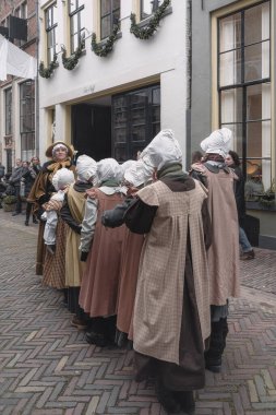 Deventer, Hollanda, 15 Aralık 2018: Hollanda Deventer 'da düzenlenen Dickens festivali sırasında öğretmen çocukları art arda kuruyor