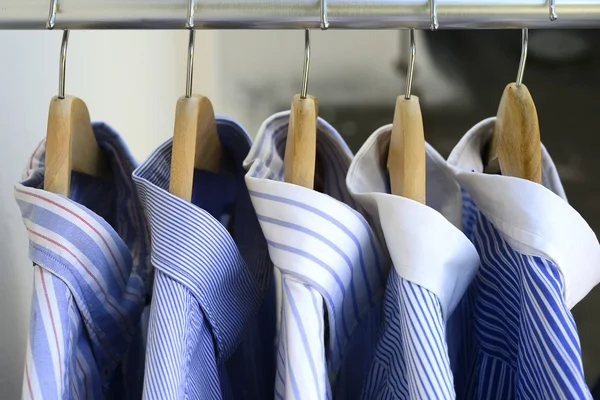 Shirts on wooden hangers — Stock Photo, Image