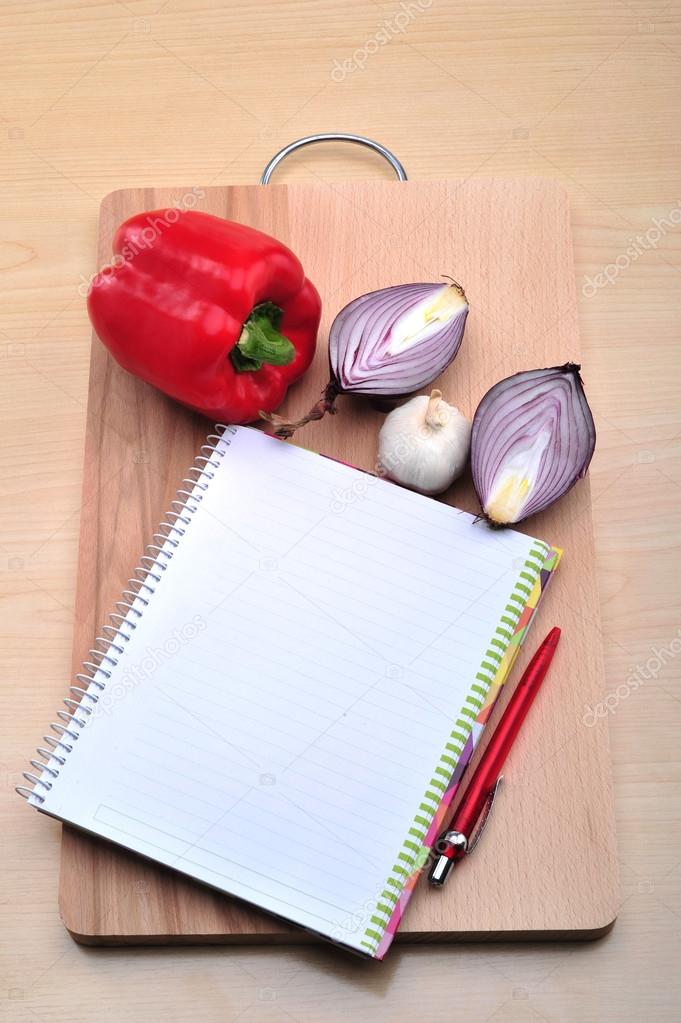 Blank recipe book with fresh pepper, onion, garlic