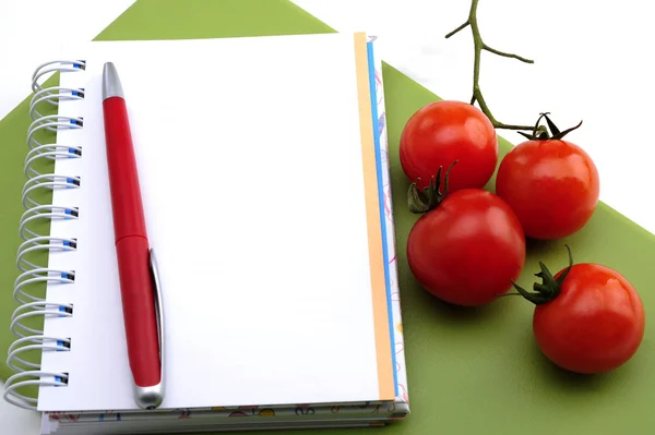 Open notebook with tomatoes — Stock Photo, Image