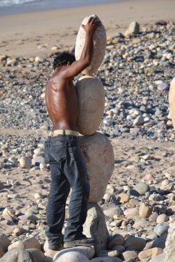 Man balancing giant rocks clipart