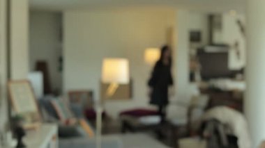 Odaya giren ve kameraya bakarak çarpıcı, genç bir kadın
