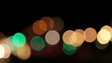 Kaydırma ile siyah arka plan ile farklı renklerde bulanık ışıklar.