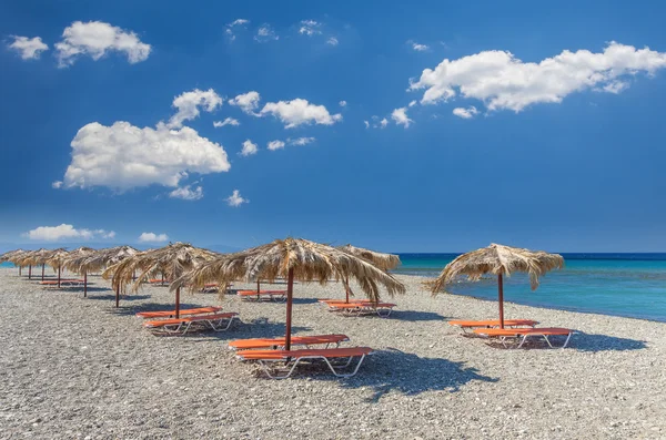 Straw umbrella on a sandy beach in Greece. — Stock Photo, Image