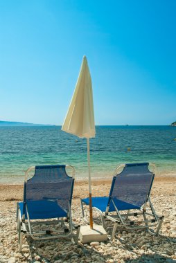 Temiz su ile güzel bir plajda şemsiye şezlong