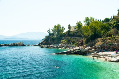 Kassiopi Beach, Corfu Island, Yunanistan. Şezlong ve şemsiyeler