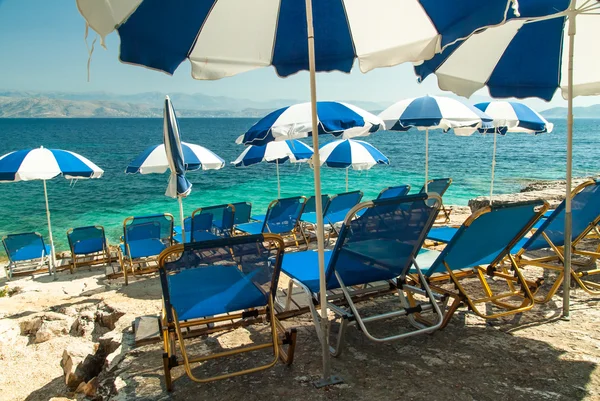 Лежаки и зонтики (зонтики) на пляже острова Корфу — стоковое фото