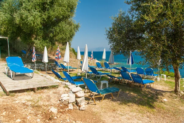 Лежаки и зонтики (зонтики) на пляже острова Корфу — стоковое фото