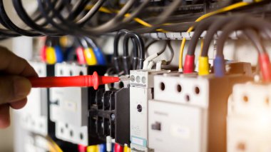Elektrik mühendisi, kabine kontrolündeki voltaj ve elektrik hattının akımını ölçen bir testçi..