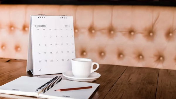 Calendar, mobile, coffee cup Placed on an old wooden table is a planning idea for success.