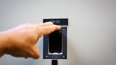 İnsan, kontrol dolabındaki düğmeleri kontrol eder..