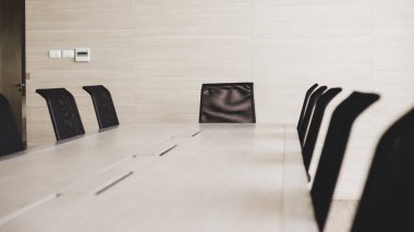 Basit modern ofis. Ahşap masa ve siyah sandalyeler..