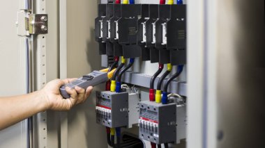 Elektrik mühendisi, kabine kontrolündeki voltaj ve elektrik hattının akımını ölçen bir testçi..