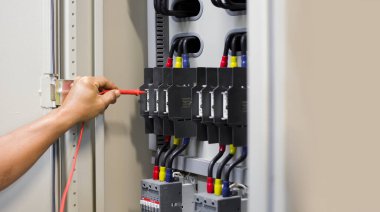 Elektrik mühendisi, kabine kontrolündeki voltaj ve elektrik hattının akımını ölçen bir testçi..
