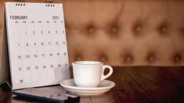 Takvim, cep telefonu, kahve fincanı eski ahşap bir masaya yerleştirilmiş başarı için bir planlama fikridir..