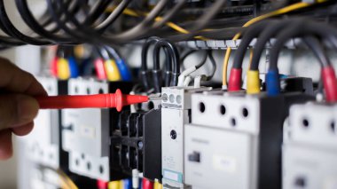 Elektrik mühendisi, kabine kontrolündeki voltaj ve elektrik hattının akımını ölçen bir testçi..