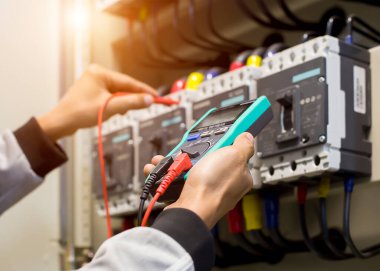 Elektrik mühendisi, kabine kontrolündeki voltaj ve elektrik hattının akımını ölçen bir testçi..