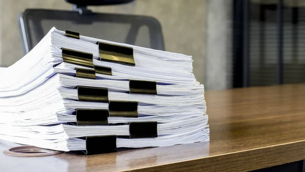 Document, Paper, File.Piles of papers placed on a dark wooden table.