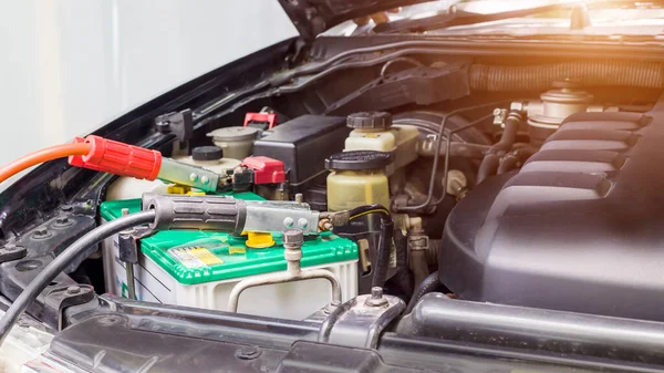 Close up Charging car battery with electricity through jumper cables.