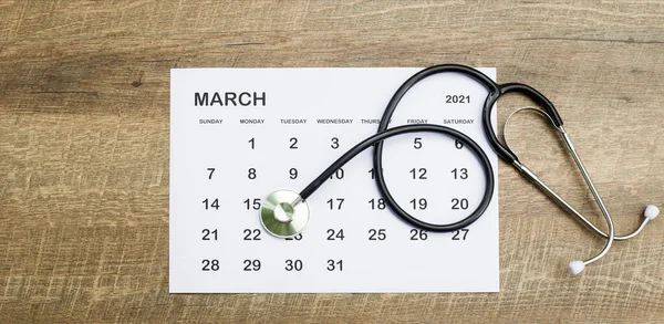 Calendar, stethoscope, on a blue background, health care concept.