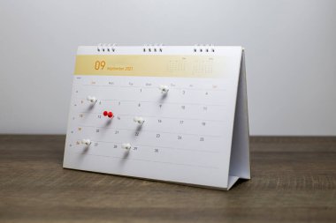 Gri arkaplanlı takvime yakın plan iş toplantısı ya da seyahat planlama fikirleri.