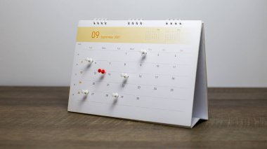 Gri arkaplanlı takvime yakın plan iş toplantısı ya da seyahat planlama fikirleri.