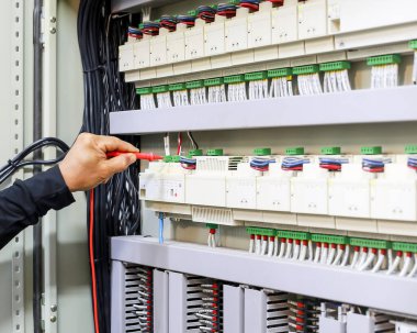 Bir elektrik mühendisi elektrik kontrol kabini bakım konseptini araştırıyor..