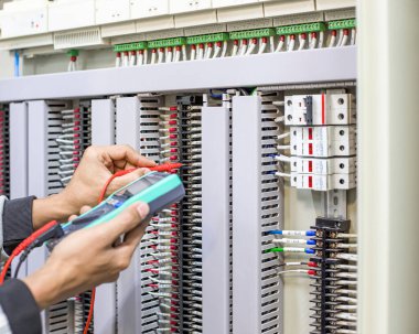 Bir elektrik mühendisi elektrik kontrol kabini bakım konseptini araştırıyor..