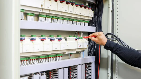 Bir elektrik mühendisi elektrik kontrol kabini bakım konseptini araştırıyor..