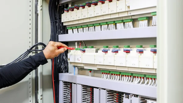 Bir elektrik mühendisi elektrik kontrol kabini bakım konseptini araştırıyor..