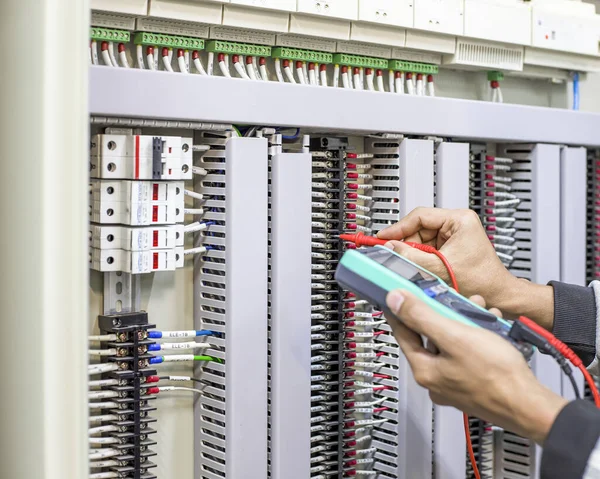 Bir elektrik mühendisi elektrik kontrol kabini bakım konseptini araştırıyor..