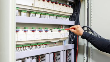 Bir elektrik mühendisi elektrik kontrol kabini bakım konseptini araştırıyor..
