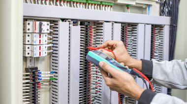 Bir elektrik mühendisi elektrik kontrol kabini bakım konseptini araştırıyor..