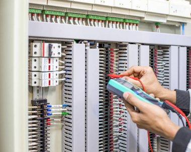 Bir elektrik mühendisi elektrik kontrol kabini bakım konseptini araştırıyor..