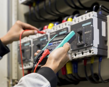 Bir elektrik mühendisi elektrik kontrol kabini bakım konseptini araştırıyor..