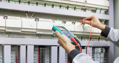 Elektrik mühendisi, kabine kontrolündeki voltaj ve elektrik hattının akımını ölçen bir testçi..