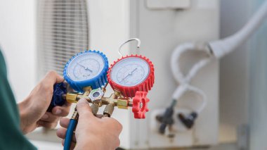 Klima teknisyeni klima sıvısını ve soğutucuyu kontrol ediyor. Klima servisi..