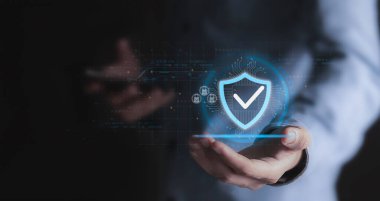 Veri koruma ve güvenlik kavramına göre, bir iş adamı bir kontrol işareti simgesi ile sanal bir kalkan tutuyor