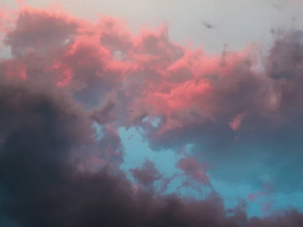 Sunset sky. Dark grey, pink and blue clouds, lush and bright clouds, summer colours, summer sky