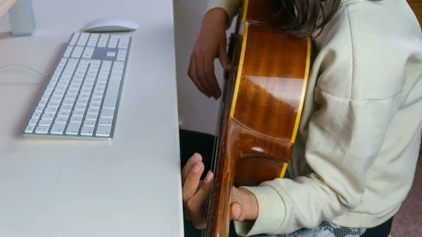 girl giving online guitar lessons, concept study from home online