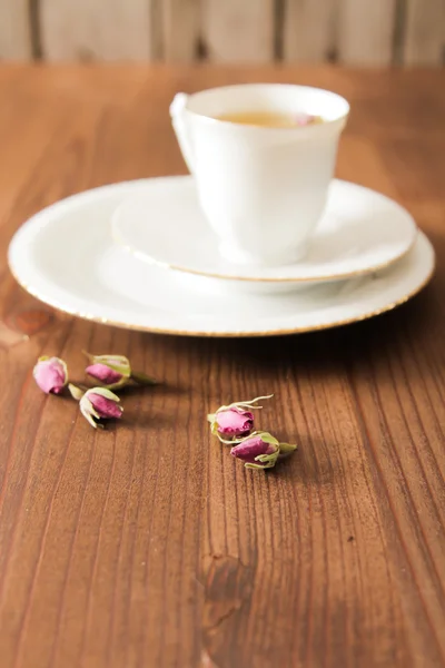 Vintage Tasse Tee mit Rosenblüten, auf braunem Hintergrund — Stockfoto